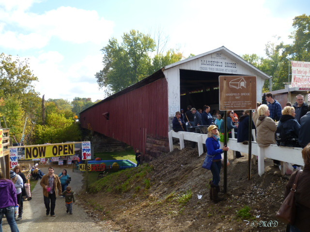 Folks line up to walk through the bridge. Down underneath, an area for children's activities.  